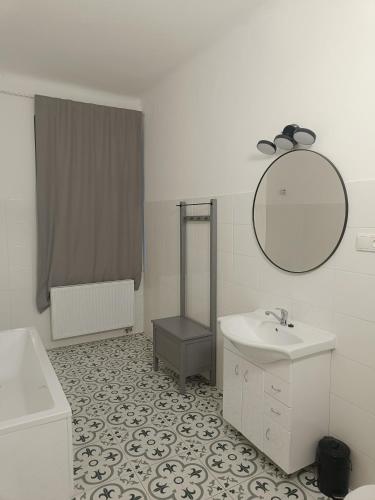 a white bathroom with a sink and a mirror at Apartmán Procyon in Prostějov