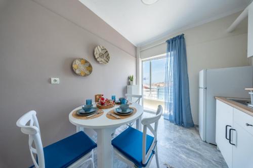 a small kitchen with a table and chairs and a refrigerator at Aether View Premium Views in Central Mytilene in Mytilene