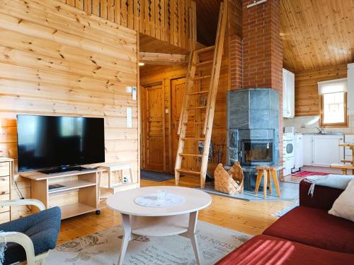 a living room with a tv and a fireplace at Kulkuri in Syöte