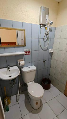 a small bathroom with a toilet and a sink at Casa FAM in Laoag