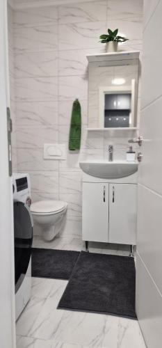a white bathroom with a sink and a toilet at Opal Skay Apartment in Doboj
