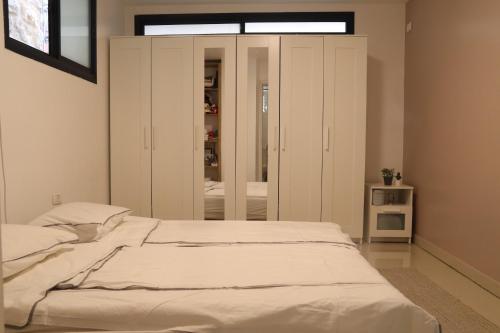 a bedroom with a large bed with white cabinets at חדשה בעתיקה - צפת in Safed