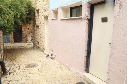 a cat sitting on the side of a building at חדשה בעתיקה - צפת in Safed