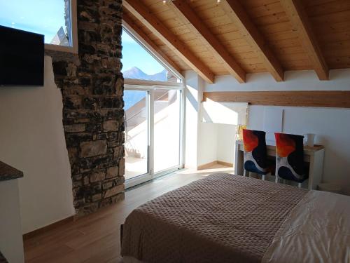 a bedroom with a bed and a large window at Casa Carlotta in Perledo