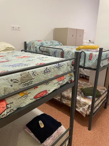 a room with three bunk beds in a room at Hostel Rural David Broncano in Orcera