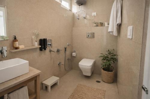 a bathroom with a toilet and a sink at Bir Haus in Bīr
