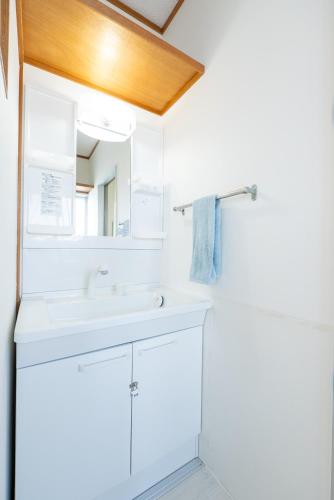 a white bathroom with a sink and a mirror at AQUAMARINE HOTEL Nagahama in Nagahama