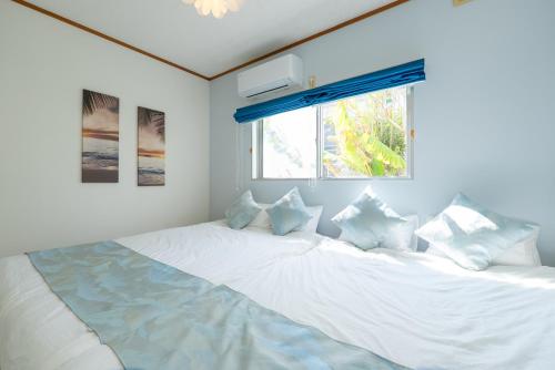 a large white bed in a room with a window at AQUAMARINE HOTEL Nagahama in Nagahama