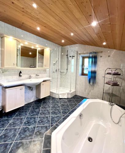 a bathroom with a tub and a sink and a shower at Lauchlehen in Bischofswiesen