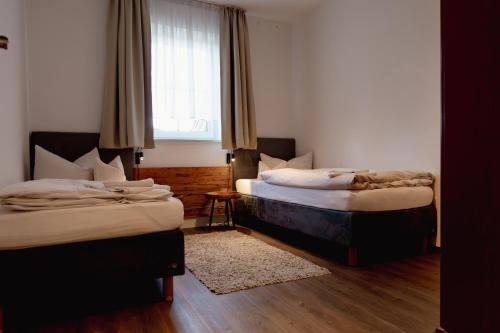 two beds in a room with a window at Der Wieshof in Riedlhütte