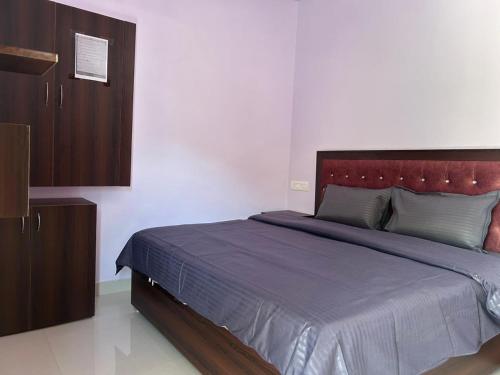 a bedroom with a large bed with a red headboard at Rautela Homestay in Lansdowne