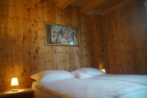 a bedroom with a bed and a painting on the wall at READYNOW Alpine Resonanz Camp für mentale Klarheit in Pill