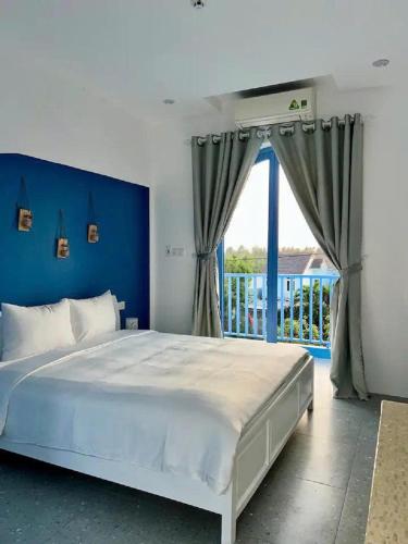 a bedroom with a large bed with a blue wall at Laco Villa in Danang