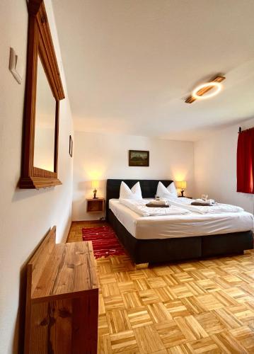 a bedroom with a large bed and a wooden floor at Lauchlehen in Bischofswiesen