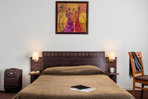 a bedroom with a bed and a painting on the wall at Aparthotel Adagio Access Paris Porte De Charenton in Charenton-le-Pont