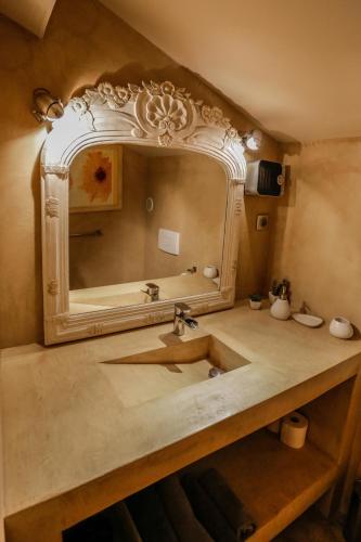 a bathroom with a sink and a mirror at Chambre d'hôtes couvent d'Alando in Alando