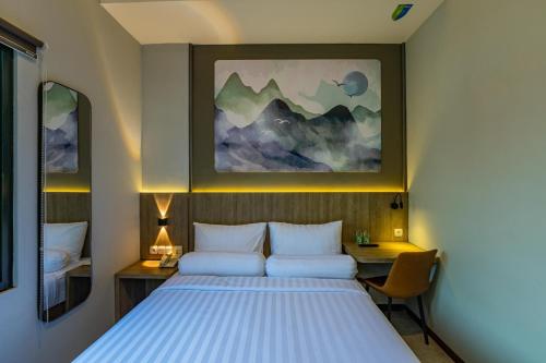 a bedroom with a bed and a painting on the wall at Front One Budget Hotel Tirtonadi Solo in Solo