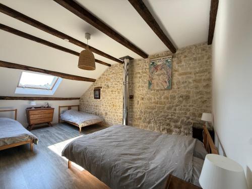 a bedroom with a bed in a room with brick walls at L'Epicerie in Melay