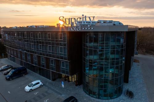 a building with a car parked in a parking lot at Suncity Hotel & SPA in Šiauliai