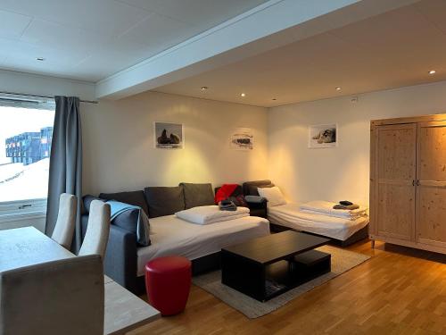 a living room with a couch and a table at Apartments with Panoramic Views in Longyearbyen