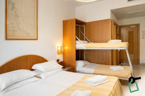 a room with three bunk beds in it at Hotiday Gallipoli Spiaggia in Baia Verde