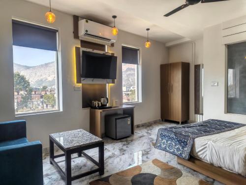 a bedroom with a bed and a tv and a couch at Hotel Jairaj in Alwar