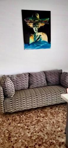 a couch in a living room with a painting on the wall at Pietra Ligure Sea View Parking & Bike Box in Pietra Ligure