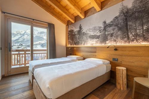 zwei Betten in einem Zimmer mit großem Fenster in der Unterkunft I Cavezàl in Valdisotto
