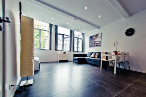 a living room with a couch and a table at Appart-Hotel Léopold Liège Centre in Liège