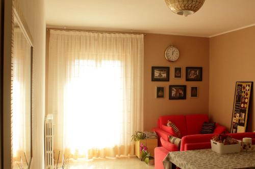 a living room with a red couch and a window at B&B Fermo d'A Mare in Fermo