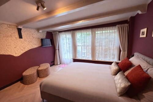 a bedroom with a large bed and a large window at BNB de Victorie Alkmaar in Alkmaar