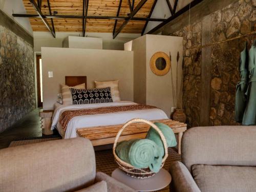 a bedroom with a bed and a couch at Springfontein River Lodge in Stanford