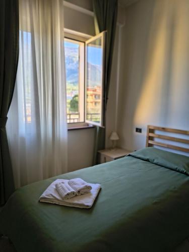 a bed with two towels on it in front of a window at Il Quadrifoglio in Frascineto
