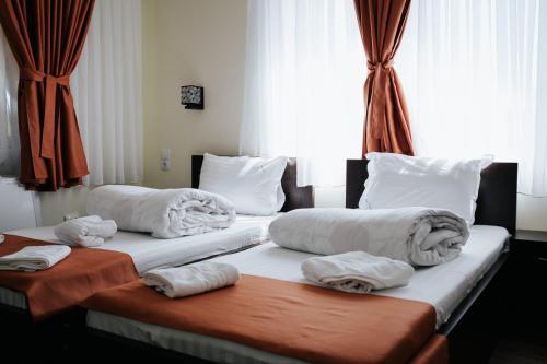 two beds in a hotel room with towels on them at Complex Turistic Suatu in Suatul
