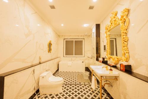 a bathroom with a toilet and a sink and a mirror at Mayfair Spring Valley Resort Guwahati in Guwahati