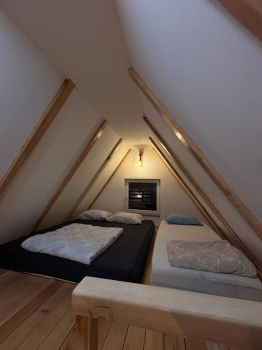 a attic bedroom with two beds and a fireplace at Vikendica Casa Verde in Konjic