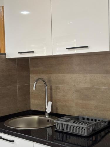 a kitchen counter with a sink and white cabinets at Vikendica Casa Verde in Konjic