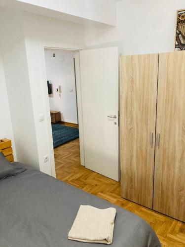 a bedroom with a bed and a wooden cabinet at Apartman 4 you 4 in Belgrade