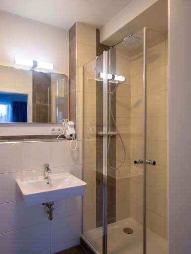a bathroom with a sink and a shower at Fairschlafen Boutique Hotel in Neustadt in Holstein