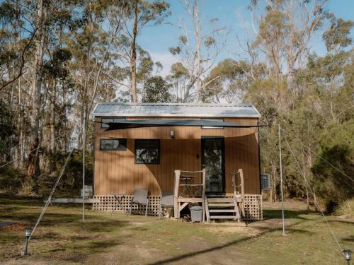a tiny house in the woods with a porch at Banyula Cove by Tiny Away in Barnes Bay