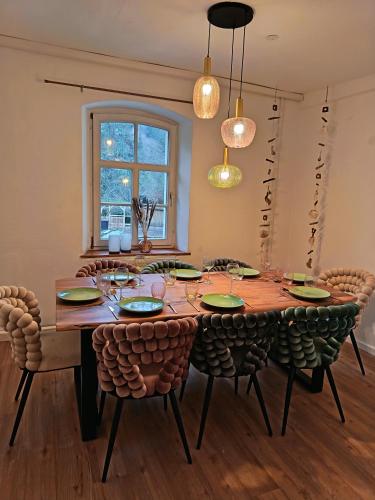 a dining room with a wooden table and chairs at Zeitinsel Doos in Waischenfeld