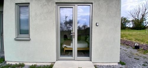 a glass door of a building with a bed in it at Cozy Double Ensuite Room in Ennistymon
