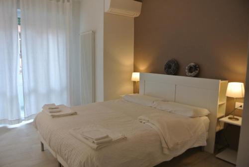 una camera da letto con un letto bianco con due asciugamani di Piano B Apartment a Trento