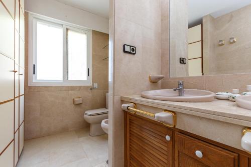 a bathroom with a sink and a toilet and a mirror at Villa Carousel in Benidorm