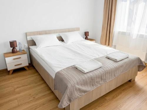 a bedroom with a large bed with two towels on it at Astral in Raszyn