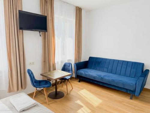 a blue couch in a living room with a table and chairs at Astral in Raszyn