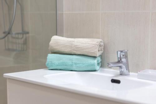 a stack of towels sitting on top of a bathroom sink at Apartamento en Cala'n Blanes in Ciutadella