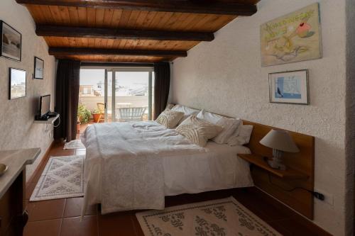 a bedroom with a large bed and a window at Seafront Iconic Lighthouse View Punta Secca in Punta Secca