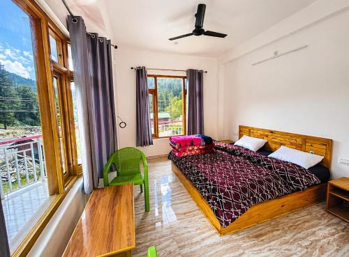 a bedroom with a bed and a large window at Barot Palace in Barot 