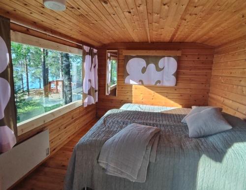 a bedroom with a bed in a wooden cabin at Kyyjärvi Camping And Hotels Oy in Kotkaniemi